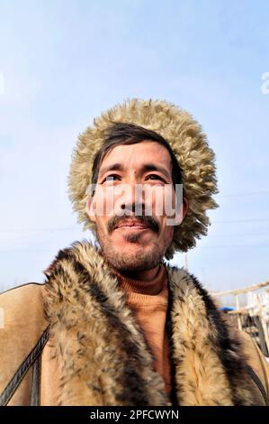 Porträt eines uigurischen Mannes mit Winterjacke. Foto auf einem Wochenmarkt in den Außenbezirken von Kashgar, Xinjiang, China. Stockfoto