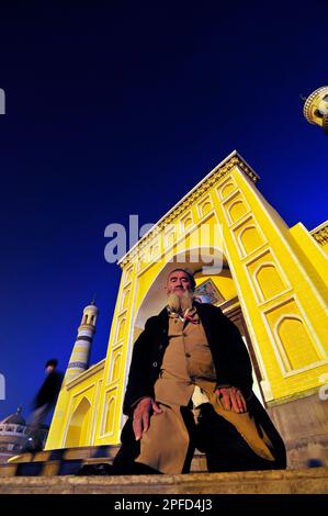 Ein uigurischer Mann betet vor der ID Kah Moschee in Kashgar, Xinjiang, China. Stockfoto