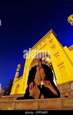 Ein uigurischer Mann betet vor der ID Kah Moschee in Kashgar, Xinjiang, China. Stockfoto