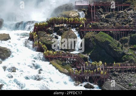 Niagara Falls Town, ON, Kanada - 30. Mai 2015: Gruppe von Touristen in gelben Regenmänteln, die die Niagarafälle beobachten und Fotos machen Stockfoto