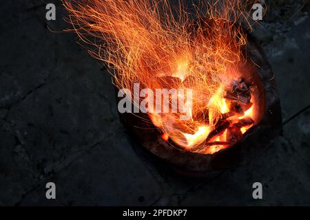 Die Flammen schwelen im Ofen. Es sieht aus wie ein Kunstwerk. Stockfoto