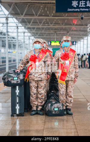 ZAOZHUANG, CHINA - 17. MÄRZ 2023 - Neue Soldaten tragen Gepäck, während sie sich auf die Fahrt mit dem Hochgeschwindigkeitszug zu ihren Baracken am Bahnhof Zaozhuang der BU vorbereiten Stockfoto