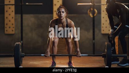 Stark genug, um alles zu erobern. Porträt einer jungen Frau, die in einem Fitnessraum mit einer Klingel Totenschleppen macht. Stockfoto