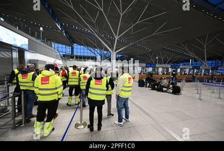 Stuttgart, Deutschland. 17. März 2023. Streikende Mitarbeiter des Stuttgarter Flughafens stehen mit Westen der Gewerkschaft Verdi in der leeren Abflughalle des Stuttgarter Flughafens. Flüge wurden wegen eines Verdi-Streiks gestrichen. Kredit: Bernd Weißbrod/dpa/Alamy Live News Stockfoto