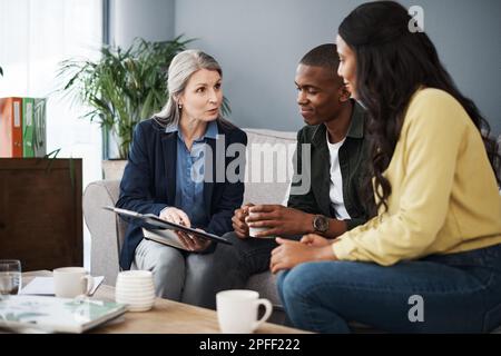 Wir waren so froh, dass du uns sehen konntest. Ein Paar, das mit einem Finanzberater zu Hause spricht. Stockfoto