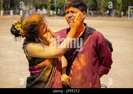 Eine indisch-bengalische Frau und ein Mann in traditionellen Kleidern, die holi spielen - das Festival der Farben Stockfoto