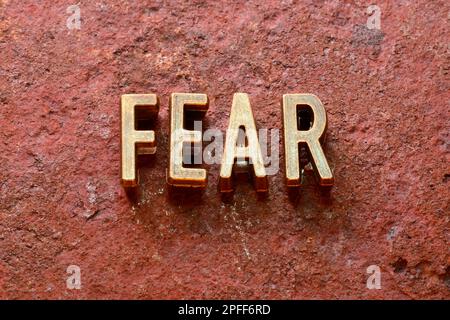 Ein Wort aus Metallic-Buchstaben auf rostiger Oberfläche Stockfoto