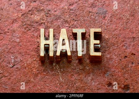 Hasswort aus metallischen Buchstaben auf rostiger Oberfläche Stockfoto