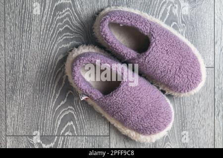 Ein Paar Wollschuhe stehen auf grauem Holzboden, Draufsicht Stockfoto