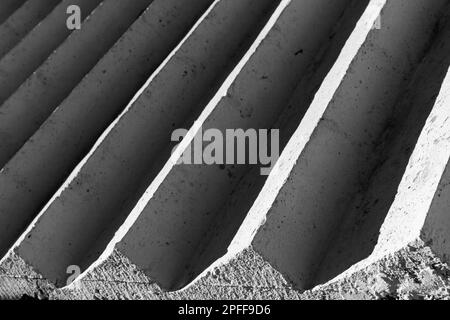 Weiße Betontreppe mit dunklen Schatten, abstrakte Architektur, Hintergrund. Schwarzweißfoto Stockfoto