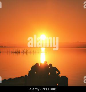 Eine Gruppe von Freunden, die den Sonnenuntergang genießen Stockfoto