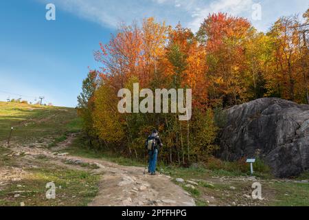 Touristen lesen im Herbst das Schild auf der Mount Tremblant-Strecke. Quebec. Kanada. Stockfoto