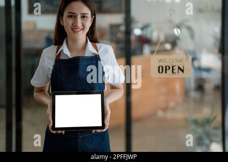 Erfolgreicher Inhaber eines kleinen Unternehmens, kmu-Schönheitssalon mit Tablet-PC, weißer Bildschirm im Café-Restaurant. asiatische Bräunungsfrau Barista Stockfoto