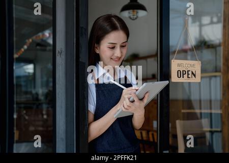 Erfolgreiche Inhaber eines kleinen Unternehmens kmu-Schönheitssalon mit Tablet im Café-Restaurant, asiatische Bräunungsfrau Barista-Café-Besitzer, Unternehmer Stockfoto
