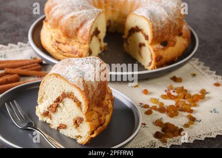 Hausgemachter Oster-Reindling-Kuchen mit Rosinen und Zimt in Nahaufnahme auf einem Teller auf dem Tisch. Horizontal Stockfoto