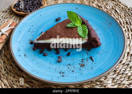 Nahaufnahme der Schokoladenchips neben der Kuchencreme auf dem Kakaokuchen. Stockfoto