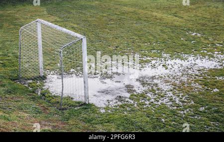 Fußballfeld in schlechtem Zustand, das Gras naß Stockfoto