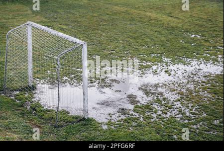 Fußballfeld in schlechtem Zustand, das Gras naß Stockfoto