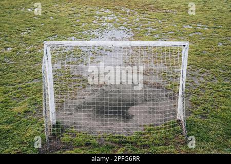 Fußballfeld in schlechtem Zustand, das Gras naß Stockfoto