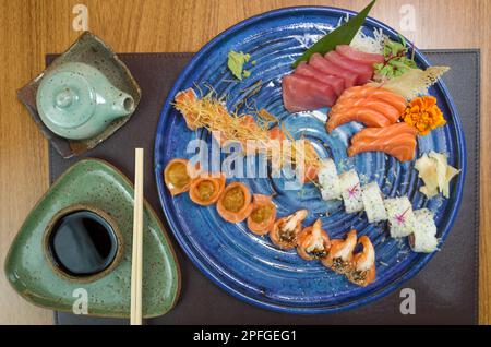 Kombiniert mit verschiedenen japanischen Sushi auf einem eleganten blauen Teller. Stockfoto