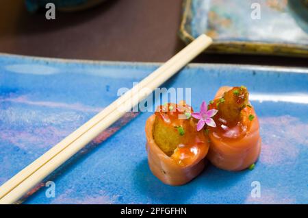 Kombiniert mit verschiedenen japanischen Sushi auf einem eleganten blauen Teller. Stockfoto