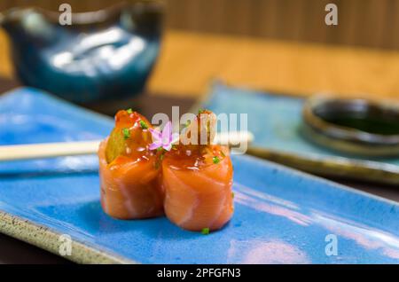 Kombiniert mit verschiedenen japanischen Sushi auf einem eleganten blauen Teller. Stockfoto