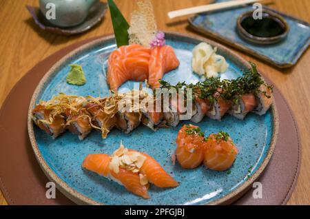 Kombiniert mit verschiedenen japanischen Sushi auf einem eleganten blauen Teller. Stockfoto