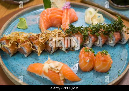 Kombiniert mit verschiedenen japanischen Sushi auf einem eleganten blauen Teller. Stockfoto