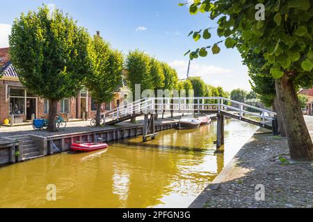 Typische weiße Holzbrücke über den Kanal in der kleinen niederländischen Stadt Sloten in Friesland. Stockfoto