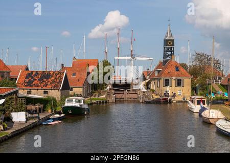 Blick auf die Schleuse, das Schlosshaus und die Holzbrücke in der malerischen Altstadt Hindeloopen in Friesland in den Niederlanden. Stockfoto