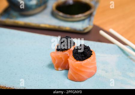 Kombiniert mit verschiedenen japanischen Sushi auf einem eleganten blauen Teller. Stockfoto