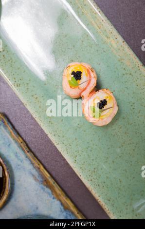 Kombiniert mit verschiedenen japanischen Sushi auf einem eleganten blauen Teller. Stockfoto