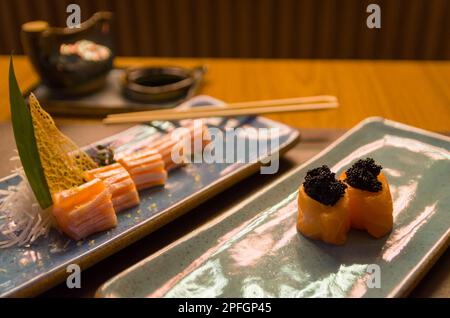 Kombiniert mit verschiedenen japanischen Sushi auf einem eleganten blauen Teller. Stockfoto