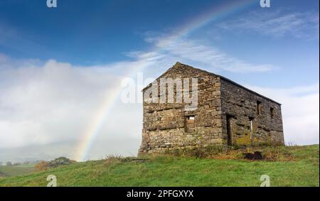 Regenbogen über einer alten Steinscheune in den Yorkshire Dales, North Yorkshire, Großbritannien. Stockfoto