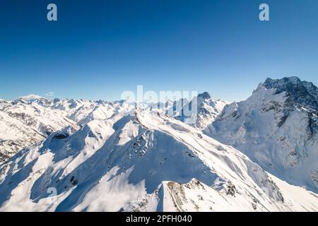 Berggipfel mit Schnee bedeckt vor blauem Himmel Stockfoto