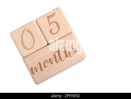 Ein Holzblock mit dem Geburtsdatum eines Neugeborenen auf weißem Hintergrund. Stockfoto