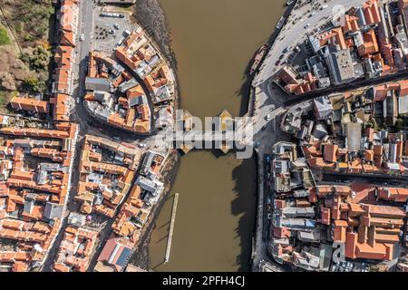 Ein Luftbild aus der Vogelperspektive direkt über der Drehbrücke, die die verschiedenen Seiten der Küstenstadt Whitby über den Fluss Esk verbindet Stockfoto