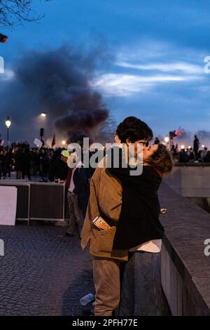 Paris, Frankreich. 16. März 2023. Ein paar Küsse, wie Demonstranten auf dem Concorde-Platz in der Nähe der Pariser Nationalversammlung demonstrieren. Der französische Präsident Emmanuel Macron hat das parlament gemieden und beschlossen, ein Gesetz durchzusetzen, das das Rentenalter von 62 auf 64 Jahre anheben würde, indem eine besondere verfassungsmäßige Macht ausgelöst würde. Kredit: SOPA Images Limited/Alamy Live News Stockfoto