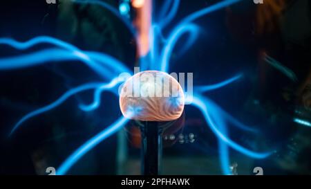 Orangefarbene Energiekugel mit blauen Plasmalichtstrahlen Stockfoto