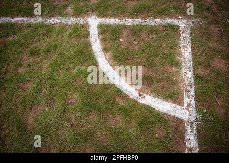 Fußballplatzmarkierungen an der Ecke auf schlammigem Spielfeld Stockfoto