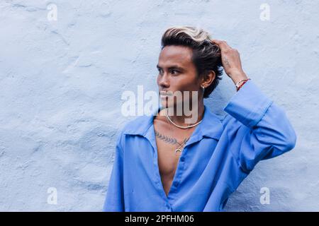 Porträt eines gutaussehenden Mannes an der blauen Wand draußen Stockfoto