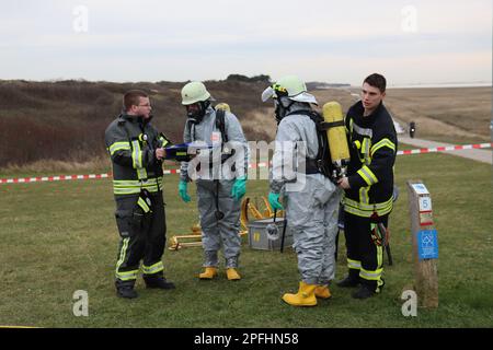 Wangerooge, Deutschland. 17. März 2023. Notfallpersonal in Schutzanzügen und Feuerwehrleute bereiten sich während einer größeren Übung des Notfallteams am nordöstlichen Strand der Insel Wangerooge vor. Während der Übung üben rund 130 Notfallpersonal Schutzmaßnahmen im Falle eines Chemieunfalls durch ein Schiffswrack aus. (Zu dpa: "Was tun bei einem Chemieunfall? Über 100 Forces Practice on Wangerooge') Kredit: Peter Kuchenbuch-Hanken/dpa/Alamy Live News Stockfoto