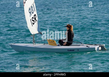 Foto einer Teenagerin, die auf einem Laser-Segelboot segelt, mit Meer um sie herum Stockfoto