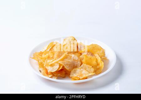Kartoffelchips auf einer weißen Platte, isoliert auf weißem Hintergrund. Draufsicht. Stockfoto