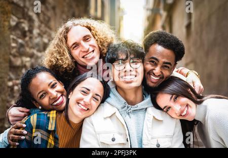 Jungs und Mädchen aus verschiedenen ethnischen Gruppen machen Selfie im Freien mit Hintergrundbeleuchtung – Happy Life Style Freundschaftskonzept für junge multiethnische beste Freunde, die Spaß haben Stockfoto