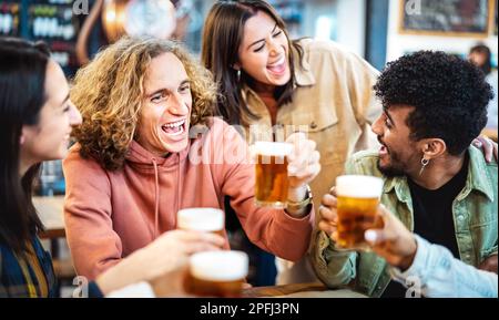 Hipsterfreunde aus verschiedenen Rassen trinken und toasten Bier im Brauerei-Bar-Restaurant – das Lebenskonzept für Speisen und Getränke mit Männern und Frauen Stockfoto