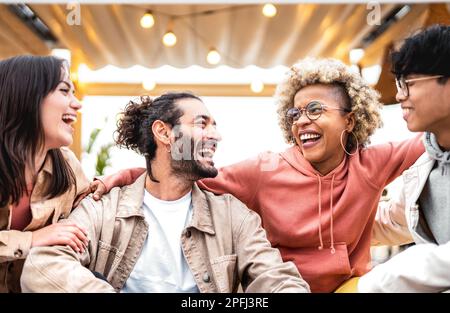 Freunde verschiedener Rassen, die Spaß an einem schicken Veranstaltungsort haben - Life Style-Konzept mit glücklichen Männern und Frauen, die Zeit zusammen verbringen - College-Studenten auf cool Stockfoto