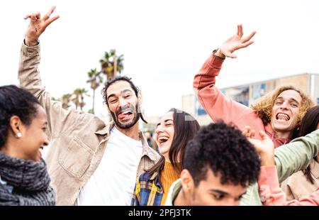 Auf der Promenade der Stadt jubeln verschiedene Freunde gemeinsam über das Life Style Concept - glückliche Männer und Frauen, die Spaß beim Spaziergang durch die Straßen von Barceloneta haben - Univer Stockfoto