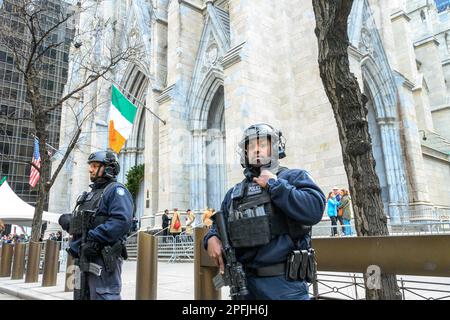 New York, USA. 17. März 2023. Schwer bewaffnete Polizisten der New York City Polizei stehen Wache vor St. Patrick Cathedral vor dem Start des St. Patrick's Day Parade am 17. März 2023 in New York City. Etwa 150.000 Menschen marschieren jedes Jahr durch die Fifth Avenue in der größten St. Patrick's Day Parade, die seit 1762 jährlich stattfindet, um das irische Erbe zu feiern. Kredit: Enrique Shore/Alamy Live News Stockfoto