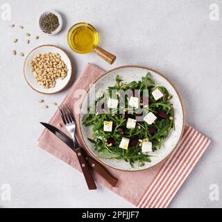Salat mit Rucola und Rüben, Pinienkernen und Käse. Viele Grüns zum Kochen. Vegetarisches Essen, Blick von oben Stockfoto